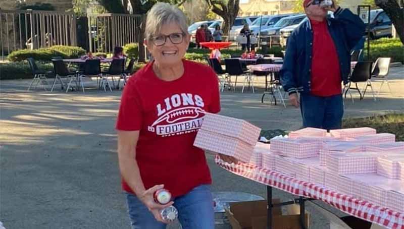 A woman and employee picking up a box of taco that Clear Fork Bank supplied for customer appreciation taco tailgate.